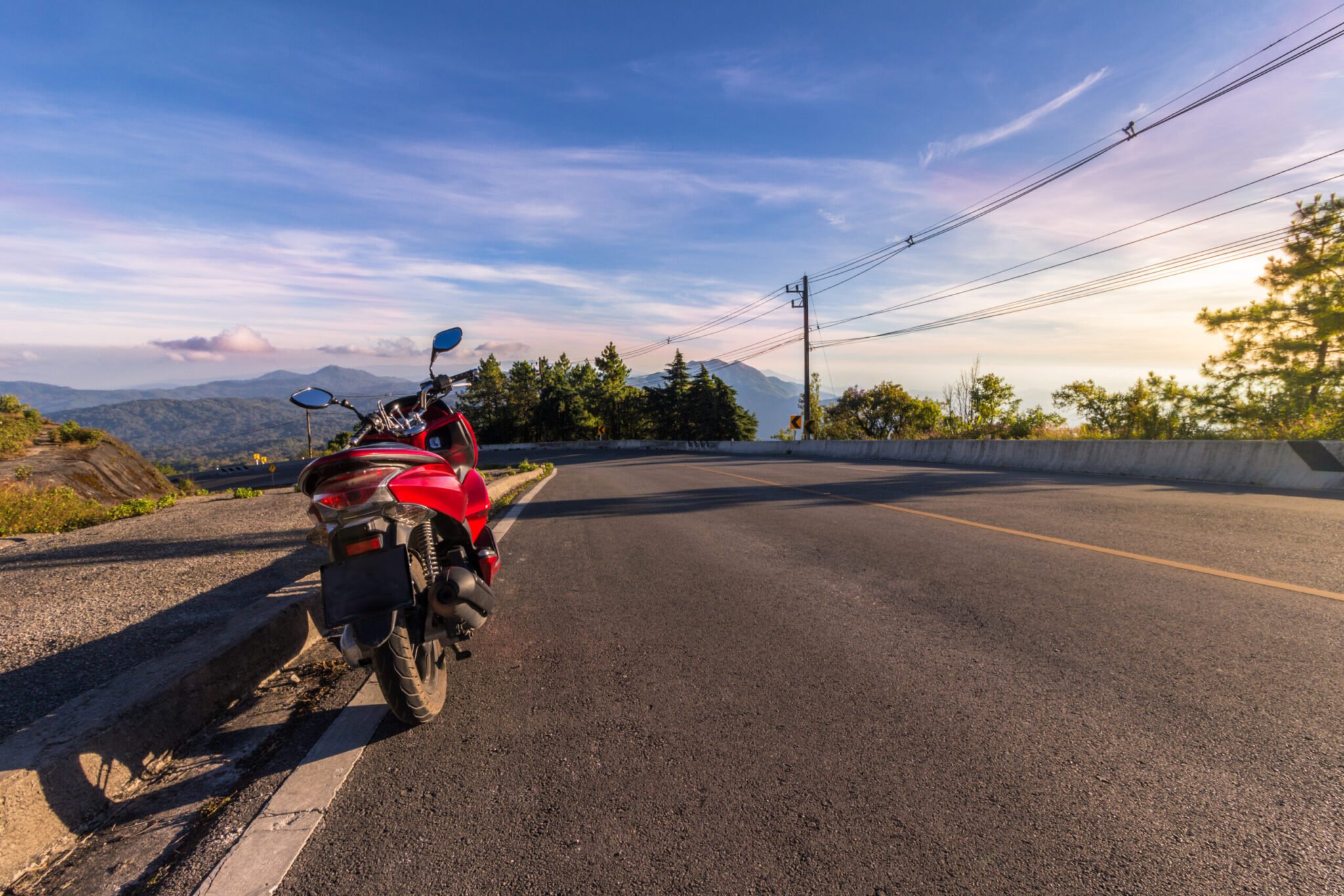 Motorcycle, serpentine road, mountains on background and blue sky on sunset. Active lifestyle and vacation concept.